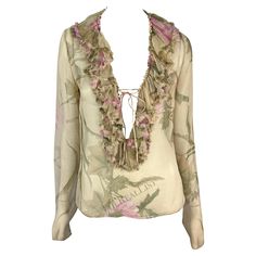 Presenting a fabulous tan sheer Gucci ruffle top, designed by Tom Ford. From the Spring/Summer 2003 collection, this chic top is covered in a bold floral print. Entirely sheer, the top features a plunging neckline framed by a ruffle accent that wraps around the neck. The top is made complete with long sleeves and a tie closure at the bust. Approximate measurements: Size - 44IT Shoulder to hem: 23" Bust: 36" Waist: 34" Shoulder to cuff: 27" Underarm to cuff: 22" Materials tag removed. Chic Luxury Gucci Tops, Gucci Long Sleeve Party Tops, Elegant Silk Gucci Tops, Fitted Gucci Top For Night Out, Gucci Fitted Luxury Blouse, Fitted Gucci Top With Button Closure, Spring Fitted Gucci Shirt, Gucci Sleeveless Fitted Top, Gucci Blouse