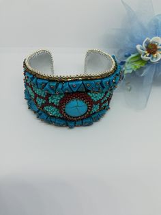 Beautiful and elegant bracelet in a slightly ethnic style, hand embroidered with a central turquoise cabochon and aulite gems. It is difficult and slow work, it took many hours of work from planning to realization of the final project. Each bead is individually hand sewn to create the final design. Inside the bracelet is covered in natural leather which gives a soft touch to the skin. This bracelet is comfortable to wear, goes perfectly with clothes of different colors. The colors used recall summer, the sea and the sun... The width of the bracelet is 4cm (1.6 inches). It has a brass plate inside that holds its shape and fits any wrist size. Wearing this bracelet will make you feel unique and special. Each piece is unique. If you would like a personalized bracelet in the colors of your cho Handmade Blue Beaded Bracelets For Festivals, Handmade Blue Beaded Bracelet For Festivals, Multicolor Embroidered Bangle Jewelry, Bohemian Embroidered Cuff Bracelet For Gift, Bohemian Embroidered Cuff Bracelet As Gift, Bohemian Adjustable Embellished Jewelry, Unique Handmade Blue Bangle, Traditional Embroidered Bangle Jewelry, Handmade Turquoise Bracelet For Festivals