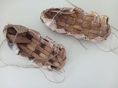 two woven baskets sitting on top of a white table next to twine strings and yarn