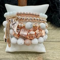 Boho Blush Bracelet Stack – where the enchanting hues of rose gold and pristine white hues come together in a whimsical dance of elegance and boho charm. This stack isn't just jewelry; it's a serenade to your free-spirited soul. Treat yourself with the Boho Blush Stack and let each bracelet tell a tale of carefree grace. So Pretty!! Wear them all on one wrist and stack 'em up or wear 3 on one wrist and two on the other with a watch! Lead & Nickel Free Bracelets are 'one size fits most' and are designed to fit wrists up to 7.5" comfortably Stretch bracelets set of 5 Off White and Rose Gold Hues Pave Crystal Embellishment Heart Charm with Leather Fringe Pull Please be aware that due to the unique and handmade nature of each product, colors, shapes, and bead sizes may vary slightly from the p Feminine Adjustable White Jewelry, Feminine White Adjustable Jewelry, Bohemian White Bangle Jewelry, White Stackable Bracelets For Party, Trendy Rose Gold Beaded Bracelets For Gifts, Adjustable Rose Gold Charm Bracelet For Parties, Adjustable White Beaded Feminine Bracelets, Trendy Adjustable Pink Gold Jewelry, White Feminine Bracelets For Party