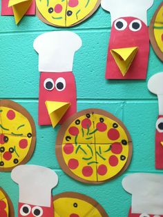 paper plate pizzas with faces and eyes are on a blue wall in front of a green background