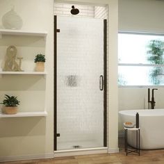 a white bath tub sitting next to a window in a bathroom with shelves on the wall