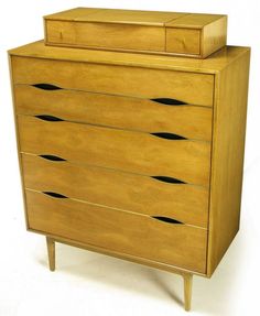 a wooden dresser with three drawers and two black holes on the bottom drawer, against a white background