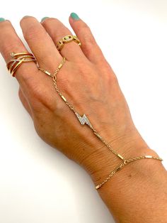 a woman's hand with five different types of bracelets and rings on it