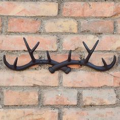 a metal deer's antlers mounted to a brick wall