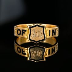 Exquisite and rare Victorian mourning ring band featuring an engraved shield signet front with the band having black enamel spelling out 'In Memory Of'.  Made in England and handcrafted in 16K gold, the black enamel letters are spaced with a fine engraved chased sections.  The inside of the band is engraved with A Gouarne died 10 May 1875 age 16.  This antique piece of mourning jewelry is extremely well crafted with exceptional details.  A museum-quality piece! Materials: 16 Karat Gold, Black Enamel Ring Size: 8 US, Q UK - We do not recommend resizing  Weight: 4.2 grams Hallmarks: Full English hallmarks 16, Birmingham, Letter z for 1874-1875 Condition: Very, very good with the engraving very crisp showing little wear even to the inside of the ring and all enamel intact. Our collection cons Signature Rings, Shield Ring, Ring Bands, Victorian Ring, Victorian Rings, Letter Z, Ring Antique, Enamel Ring, Unique Antiques