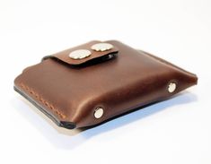 a brown leather wallet with two white buttons