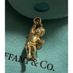 Tiffany & Co. 18k Yellow Gold Cherub Angel Charm Pendant 4 Necklace & Bracelet *Charm Only - Solid Gold 7g Never Worn, Was Cut From The Chain Bracelet, So The Ring Is Open, Any Jeweler Can Solder It Back. In Excellent Condition - Light Hairline Scratches Throughout A Staple Piece For Any Tiffany Lover Or A Great Gift Idea. Metal: 18k Gold Weight: 7 G Pendant: Charm Size Is Approximately 1-1/8” With Bail ( 1” Without The Bail) Hallmarks: T&Co. / 750 Authenticity Guarantee Program Comes With A Pou Luxury Gold Jewelry With Logo Charm, Gold-tone Jewelry With Logo Charm For Formal Occasions, Classic Formal Jewelry With Logo Charm, Luxury Charms Jewelry For Formal Occasions, Luxury Jewelry Gift With Logo Charm, Elegant Gold Plated Jewelry With Logo Charm, Luxury Formal Jewelry With Charms, Luxury Logo Charm Jewelry For Gift, Designer 14k Stamped Yellow Gold Jewelry