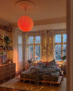 a bed room with a neatly made bed and lots of lights on the windowsill