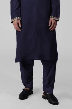 Navy blue kurta featuring intricate tilla embroidery and delicate gold silk thread work on the front placket, sleeves, and neckline. Paired with a pathani salwar.
Components: 2
Pattern: Embroidered
Type Of Work: Tilla
Neckline: Band collar
Sleeve Type: Long
Fabric: Silk
Color: Blue
Other Details: 
Attached lining
Length:
Kurta: 47 inches
Sleeve: 27 inches
Placket: 15.5 inches
Salwar: 42 inches
Occasion: Mehendi and Puja - Aza Fashions Embroidered Slub Silk Sherwani For Eid, Eid Embroidered Slub Silk Sherwani, Embroidered Slub Silk Sherwani With Traditional Drape, Traditional Embroidered Slub Silk Sherwani, Traditional Slub Silk Sherwani For Transitional Season, Eid Cotton Silk Traditional Wear With Embroidered Border, Traditional Cotton Silk Bandhgala For Ceremonial Occasions, Indigo Straight Kurta With Dabka, Indigo Dabka Straight Kurta