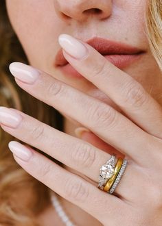 a close up of a woman's hand with a diamond ring on her finger