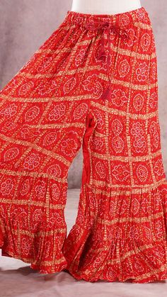 PRODUCT DETAILS These are beautiful Bandhini Palazzos pants that are tiered and have flary hem. The waist has a stretch elastic band with tying strings for a good fit. It is made of paper silk fabric, which has a very good flow. It resembles crushed satin silk. You can wear this with an Indian Kurti or a stylist western top!! Your creativity is the limit with these colorful, printed Palazzo pants! :) Size: One Size Length: 38 inches In seam: 25 inches Waist: expands upto 42 inches Material & Car Red Ruffled Sharara For Diwali, Anarkali Style Tiered Skirt Sharara For Festivals, Anarkali Sharara With Tiered Skirt For Festivals, Festive Fitted Palazzo Set With Ruffles, Fitted Ruffled Palazzo Set For Festive Occasions, Anarkali Ruffled Sharara For Festivals, Fitted Red Sharara With Ruffles, Wedding Festival Tiered Skirt Sharara, Festival Anarkali Sets With Tiered Skirt