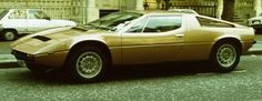 a brown sports car is parked on the street