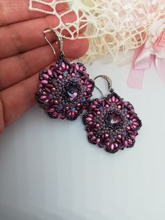 Beautiful pendant earrings made using the weaving technique with Toho beads, bicones, superduo and others. In the center is a pink-purple glass crystal set with rocailles in shades of light purple. Around the crystal there are rounds of different types of beads and crystals which make the earrings bright and very elegant. The motif used is floral. The length is 6 cm. They attach with a very pretty silver hook to the lobe. They can be customized by making them in different shades and colors. The earrings are really very bright and elegant, suitable for an evening dress for a special occasion. A great gift for her. All jewels are delivered in a decorated box, ready to be given as a gift to your loved one. How to take care of your jewellery: put on your beauty products (cosmetics, perfumes, . Earrings With Crystals, Super Duo, Toho Beads, Purple Earrings, Precious Jewels, Crystal Set, Purple Glass, Glass Crystal, Pink And Purple