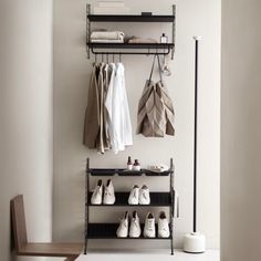 an organized closet with shoes and coats hanging on the wall, along with other items