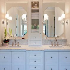 a bathroom with double sinks and two mirrors