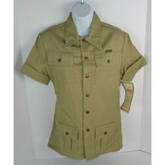 Vintage - 1970's Women's Maverick (Blue Bell) Safari Style Shirt - Bronze Snaps - Elastic Back At Waist 55% Polyester, 45% Cotton, Nice Heavy Duty Feel - Khaki Tag Size Large Actual Measurements - 18.5" Pit To Pit, 16" Shoulder Seam To Shoulder Seam, 16" Across And Unstretched At Waist, 26.5" Back Of Collar To Bottom Hem New Old Stock With Tags. Excellent Condition. Khaki Short Sleeve Camp Shirt For Spring, Military Style Short Sleeve Top With Pockets, Military Style Khaki Top For Summer, Khaki Military Style Summer Top, Military Style Collared Cotton Top, Khaki Shirt With Camp Collar For Spring, Retro Short Sleeve Tops With Pockets, Vintage Summer Tops With Pockets, Khaki Collared Camp Shirt With Pockets