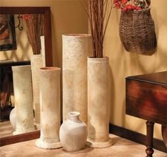 four vases are sitting on the floor in front of a mirror