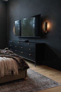 a bedroom with a large bed and a flat screen tv mounted on the wall above it