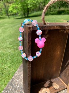 a bag with a mickey mouse bead necklace hanging from it's front door