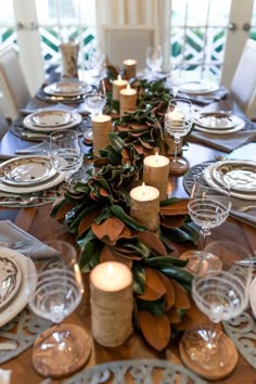 the table is set with candles, plates and place settings for dinner guests to enjoy