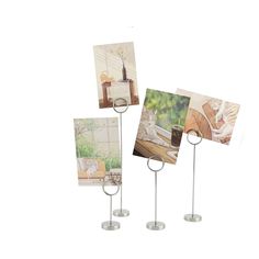 three pictures are placed on metal stand with two candles and one has a candle holder