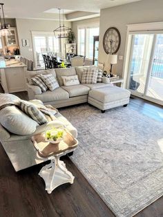 a living room filled with furniture and a large clock hanging above the couches on the wall