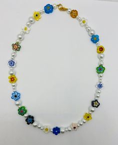 Beautiful Flower Shaped Murano Glass Millefiori Bead and Pearl Necklace Made with multicolor flower shaped Millefiori beads(11-13mm) and white glass pearls(4-8mm) Strung on sturdy jewelry beading wire with a gold stainless steel lobster claw closure. Necklace shown is 18" long, but other lengths are available. All items can be customized, please message me with your requests. ChooseLoveDesignsCo Multicolor Beaded Necklaces With Flower Charm, Beaded Flower Pearl Necklace, Flower-shaped Beaded Pearl Necklace, Flower Shaped Beaded Pearl Necklace, Pearl Beaded Flower Necklace, Pearl Beaded Necklace With Flower Shape, Adjustable Pearl Flower Beaded Necklace, White Flower Necklace With Colorful Beads, Pearl Flower Beaded Necklace