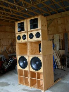 a large wooden speaker stand in a garage