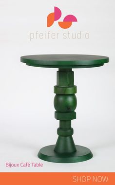 a green table sitting on top of a white floor next to a sign that says peter studio