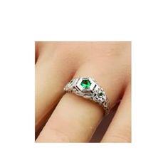 This exquisite vintage ring features a stunning simulated emerald set in anti-tarnish rhodium plated 925 solid sterling silver. The intricate filigree design adds a touch of elegance to the piece, complemented by the simulated emerald accent stones. You can find the 925 stamp on the ring, indicating its high quality and authenticity. Silver Emerald-cut Rings For Collectibles, Vintage White Gold Promise Ring Jewelry, Antique Emerald Ring For May Birthstone Gift, Vintage Emerald Cut Ring For Gift, Vintage Emerald Cut Emerald Ring For Gift, Vintage Emerald Cut Ring As Gift, Vintage Emerald Cut Emerald Ring As Gift, Vintage Crystal Ring With Birthstone For Gift, Vintage Silver Jewelry With Accent Stones