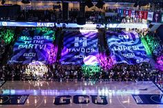 a basketball court filled with lots of people and banners that read welcome to the party