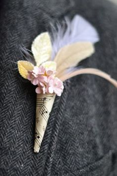 a piece of fabric with flowers and feathers attached to the back of a man's jacket