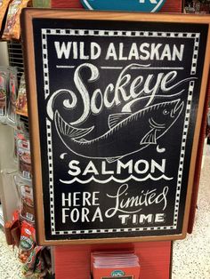 a chalkboard sign advertising seafood at a grocery store