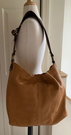 This bag is very soft, very slouchy unlined pebblegrain. Color Cognac, with brass hardware, Dark Brown harness-quality shoulder strap with Ivory topstitching. Shoulder strap is 2 1/2" wide at the shoulder tapering to 1 1/4" wide at the ends; attachments are the same leather as the strap. Bag has an open interior which closes with a single leather-mounted snap. Bag has attached unlined pebblegrain flat pouch with a single snap close for carrying smaller items. My apologies for the poor interior shot; because of the bag's slouchiness I was unable to adequately hold it open with one hand while photographing it.  Please Note: The bag's dimensions have been taken utilizing its side and bottom construction seams.  Dimensions: Length, measured across the top at maximum length 19" Width, measured Classic Pebbled Leather Shoulder Bag For Fall, Fall Shoulder Bag In Pebbled Leather With Gold-tone Hardware, Fall Shoulder Bag With Pebbled Leather And Gold-tone Hardware, Classic Fall Pebbled Leather Shoulder Bag, Fall Pebbled Leather Shoulder Bag With Gold-tone Hardware, Classic Hobo Tote Bag With Adjustable Strap, Classic Hobo Bag With Adjustable Strap, Classic Textured Leather Hobo Tote Bag, Classic Textured Leather Hobo Shoulder Bag