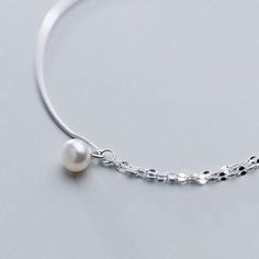 This stunning silver anklet boasts a charming baroque pearl drop dangling from a unique combination of half snake chain and half twisted chain, all made with high-quality 925 sterling silver. Experience the ease and beauty of wearing this anklet, perfect for adding a touch of elegance to your summer ensemble. Materials: 925 sterling silver, fresh water pearlLength: 8.25 + 1.25 inches Jewelry Care: See more information about how to care for your jewelry here. Shipping Policy: Orders will be shipp Elegant Sterling Silver Snake Chain Bracelet, Elegant Pearl Anklets With Pearl Chain, Minimalist Silver Pearl Bracelet With Adjustable Chain, Elegant Silver Anklets With Pearl Chain, Elegant Pearl Chain Anklets, Elegant White Anklets With Pearl Chain, Elegant Silver Chain Anklets, Elegant Sterling Silver Anklets With Adjustable Chain, Elegant White Pearl Chain Anklets