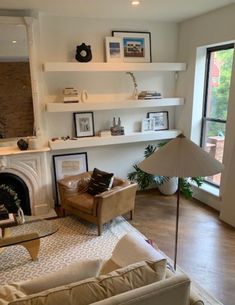 a living room filled with furniture and a fire place in front of a large window