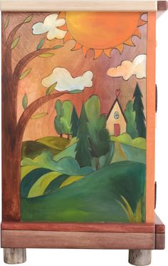 a small wooden box with a painting on it's side and trees in the background