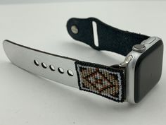 This purchase includes a Beaded Laser cut Leather iBand for Apple WATCH 38/40/41mm and is the S/M size. The Apple WATCH is not included. This Laser cut beaded leather band works with Apple Watch Series 1 38mm thru Series 9 41mm and is the S/M size. The Bead work is done by Dwight Nathaniel of the Navajo Nation. This band is v5.2 and has a smaller button and smaller holes and will last longer than previous versions. The beads are made of glass and have a rug design that nicely matches the silver leather band. The band is similar to the original Apple Watch bands but is made of leather which is about 1.2mm thick. The leather has a silver color on one side and has a water-resistant coating on the inside. The bead work is hand sewn onto the leather. Only the M/L is available with this band. Th Leather Apple Watch Band, Navajo Nation, Laser Cut Leather, Apple Watch Bands Leather, Apple Watch Series 1, Apple Watch Band, Apple Watch Series, Leather Band, Rug Design