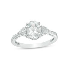 Set a sophisticated tone in this glamorous fashion ring. Crafted in sterling silver, this timeless design features an 8.0 x 6.0mm oval-shaped lab-created shimmering white sapphire flanked by trios of diamond accents - each artfully set to enhance size and sparkle. Buffed to a brilliant luster, this look glistens with elegance. Custom-made to fit her ring size. Sterling silver rings cannot be resized after purchase. Elegant White Rings With Accent Stones, White Oval Diamond Ring With Prong Setting, Classic White Topaz Ring With Diamond Accents, White Rings With Accent Stones For Formal Occasions, Formal White Rings With Accent Stones, Timeless White Jewelry With Accent Stones, Classic White Diamond Ring With Accent Stones, Classic Oval Topaz Ring With Center Stone, Classic Oval White Ring