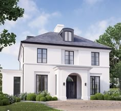 a white two story house with black trim on the front door and windows, surrounded by green bushes