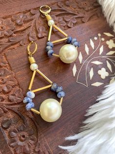 "These are large, beaded dangle earrings featuring blue sodalite beads, brass and gold plated spacer beads, a 16mm faux pearl focal bead, and 6mm faux pearl beaded top. These gorgeous and unique earrings hang approximately 3.0\" inches from the lobe. The closure is a 22k gold plated leverback and should be suitable if you have a metal allergy or sensitivity. These earrings are semi-lightweight and comfortable for extended wear. If you are not satisfied with your purchase, contact me within 14 da African Beaded Bracelets, Wire Jewelry Earrings, Blue Beaded Bracelets, Earrings Big, Blue Sodalite, Coral And Gold, Beads Earrings, Beaded Top, Beaded Dangle Earrings