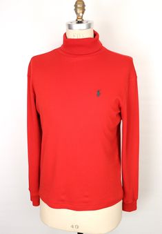 "\"The Rockefeller Center\" vintage 1990s turtleneck by iconic American designer label Polo Ralph Lauren in rich red 100% soft cotton with classic embroidered chest logo of polo player in green--Beautiful condition!  SIZE: Tagged Men's Small MEASUREMENTS (unstretched Chest (underarm to underarm): 21\" Waist: 20\" Length (base of back collar to hem): 25.5\" Turtleneck Collar (folded): 2.5\" Shoulder: 19.5\" Sleeve: 23.5\" *All measurements taken seam-to-seam lying flat and should be doubled where Ralph Lauren Turtleneck, Green Polo, Rockefeller Center, Designer Label, Green Logo, American Design, Sweater Outfits, Pullover Sweaters, Polo Ralph