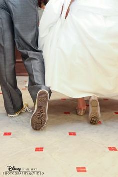 two people standing next to each other on the ground with shoes in front of them