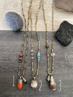 Unique and powerful beaded ethnic necklaces. Made with black wax string, small round and rectangular brass beads and each has a unique and different Tibetan pendant with white metal embossed details and different stones. Some are made with Carnelian stone, Tibetan Conch shell, Coral, Turquoise, black Pearl etc etc. Each necklace also has a different unique bead taking part of the necklace, either glass bead, stone bead etc. They don't have a clasp, all of them you wear them over the head. A perf Traditional Necklaces With Silver Beads For Meditation, Adjustable Polished Bead Necklaces For Rituals, Adjustable Brass Necklace With Polished Beads, Bohemian Brass Beaded Necklaces With Natural Stones, Spiritual Metal Beaded Necklaces, Adjustable Polished Beads Necklace For Rituals, Gold Adjustable Amulet Beaded Necklaces, Handmade Spiritual Metal Beaded Necklace, Festival Bronze Beaded Necklaces