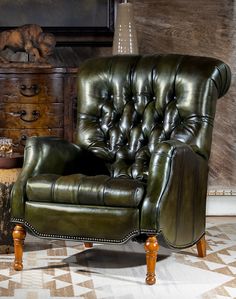 a green leather chair sitting on top of a checkered floor next to a dresser