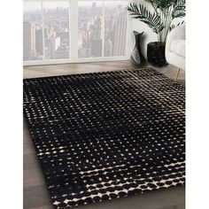 an area rug with black and white designs on it in front of a large window