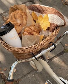 a basket filled with bread and rolls on top of a bike