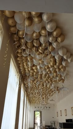 the ceiling is decorated with balloons and streamers in gold and silver colors, hanging from the ceiling