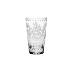 a clear glass with leaves and dots on it's rim, sitting on a white background